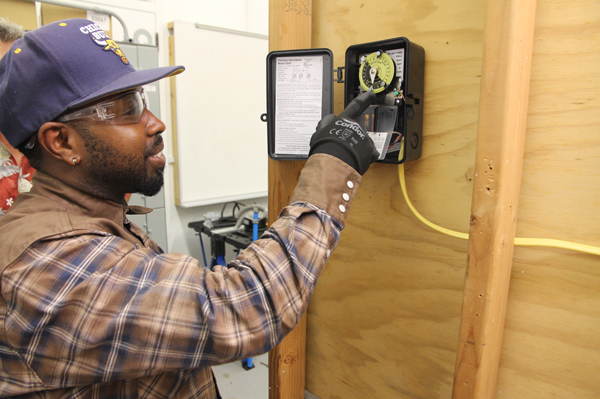 College of the Mainland electrical student Billy Matthews sets a time clock he wired to go on and off at certain times.