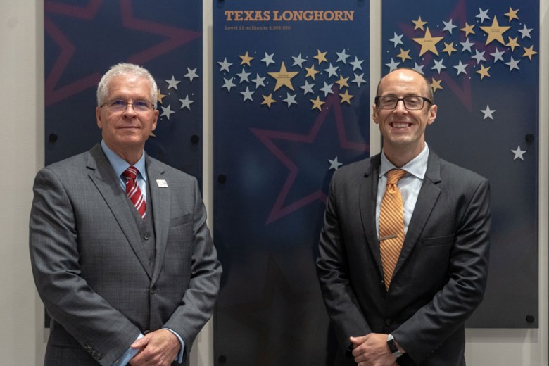 College of the Mainland President Dr. Warren Nichols and Craig Witherspoon, regional safety services manager at Texas Mutual Insurance Company, stand in front of the Donor Recognition Wall.