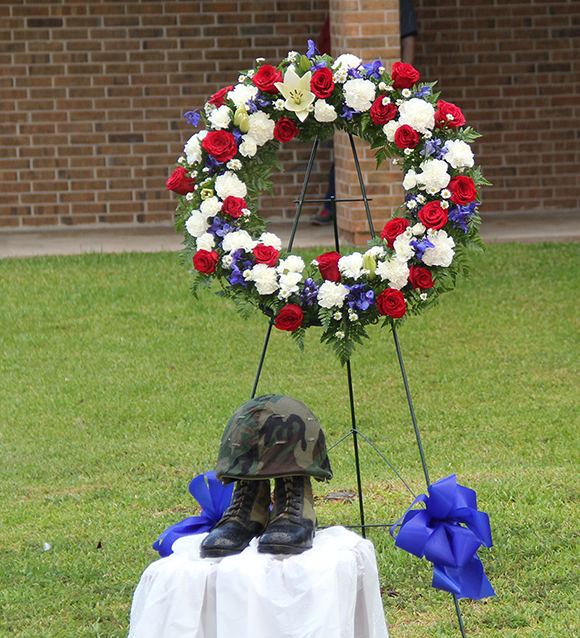 A red, white and blue wreath was on display as were a pair of combat boots and helmet and a flag representing each branch of the military.