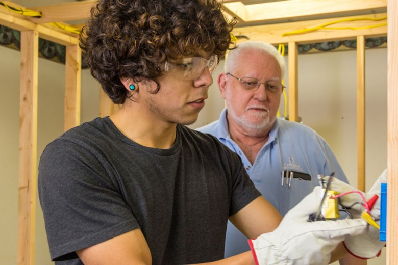 Student taking electrical training while the instructor observes.