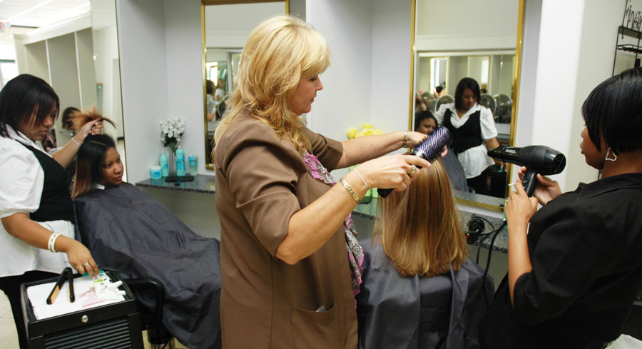 Students in cosmetology class styling hair