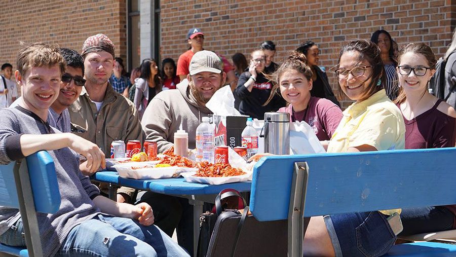 Large group of students eating outside at an event