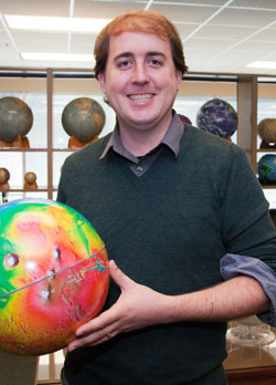 Nicholas Castle holding a colorful globe of the earth