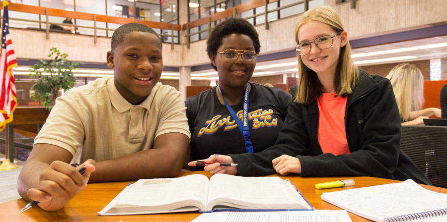 Three TRIO students studying together in the library.