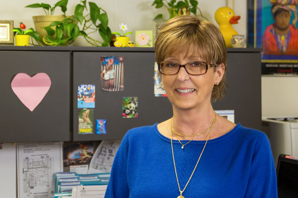 Photo of Cindy Cobb at her desk in the Humanities Office