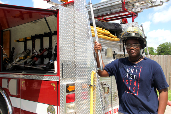 Pictured, student Jo-‘el Pickett-Frederickson explores COM’s fire engine and firefighter equipment.