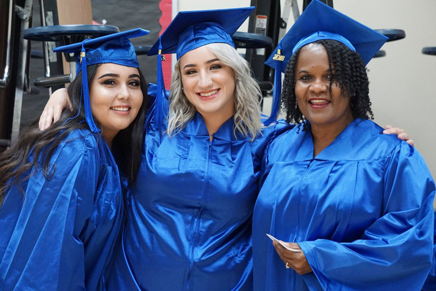 Three female students at a graduation ceremony.