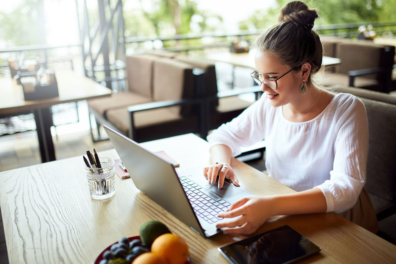 Female studying on her laptop in a cafe.