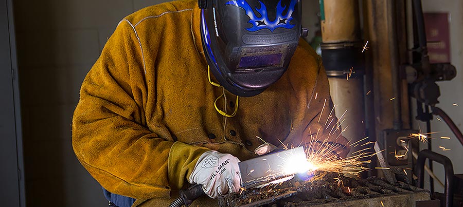 Student Welding a piece of metal